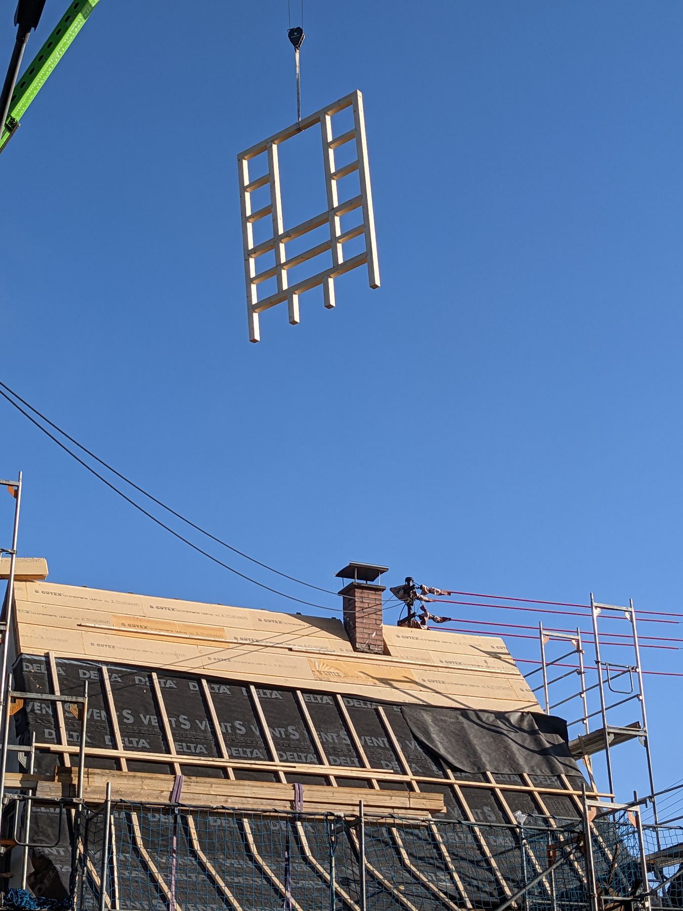 Dachsanierung mit Kran und Holzbauteilen